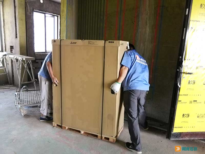 三菱电机家用中央空调安装师傅正在搬运室外机